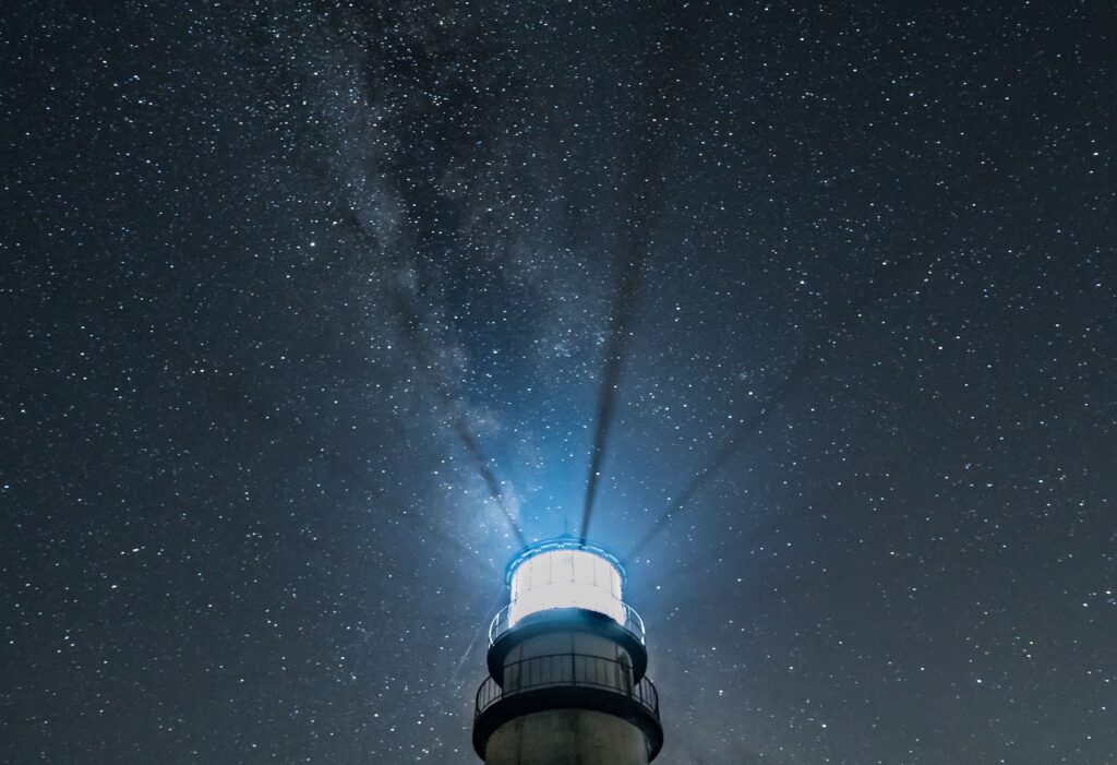 lighthouse at night shining in the sky